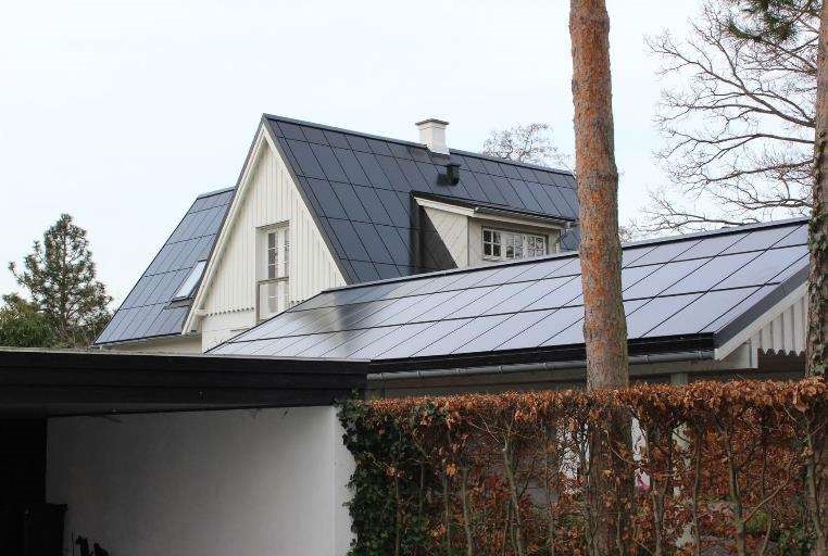 Solcelletag på hvidt hus, hvor panelerne dækker tagfladen